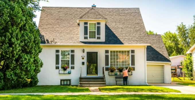 White single-family house exterior with front lawn and garden